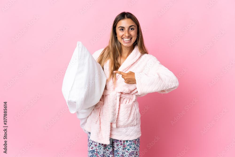 Young hispanic woman over isolated pink background in pajamas and with surprise facial expression Young hispanic woman over isolated pink background in pajamas and with surprise facial expression