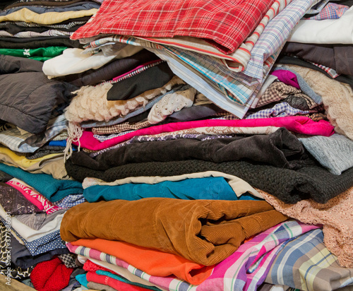 Piles of secondhand clothes. Clothing. Thriftshop. Recycling. Cradlle to cradle. Sustainability. Textile fabric clothes. up cycling, fashion industry pollution, reuse of garment.