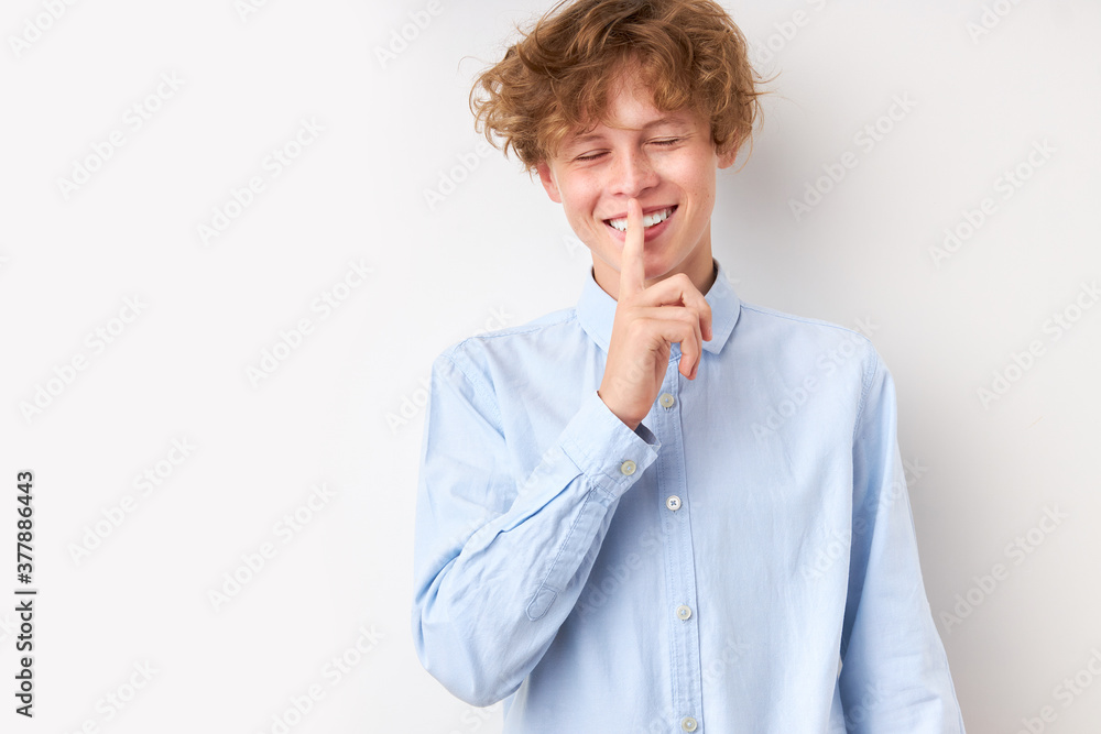 handsome caucasian boy has a secret, show silence gesture at camera. keep silence, don't talk handsome caucasian boy has a secret, show silence gesture at camera. keep silence, don't talk