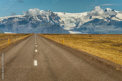 The Ring road with mountains covered by snow in the background during a sunny day on Iceland