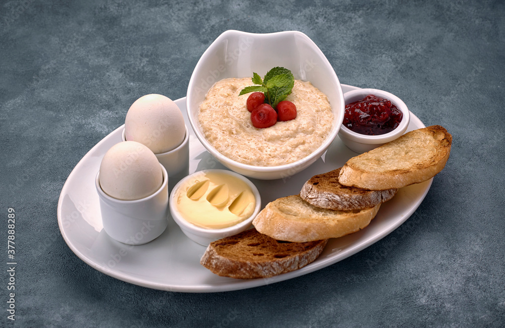 Breakfast of porridge, butter, boiled eggs, jam and toast, croutons Breakfast of porridge, butter, boiled eggs, jam and toast, croutons