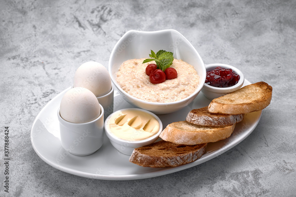Breakfast of porridge, butter, boiled eggs, jam and toast, croutons Breakfast of porridge, butter, boiled eggs, jam and toast, croutons