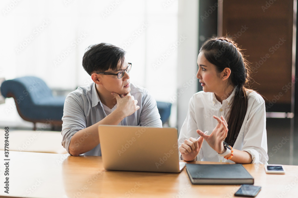 Asian business people man and woman conference talking and working with laptop together. Young couple work at home. Asian business people man and woman conference talking and working with laptop together. Young couple work at home.