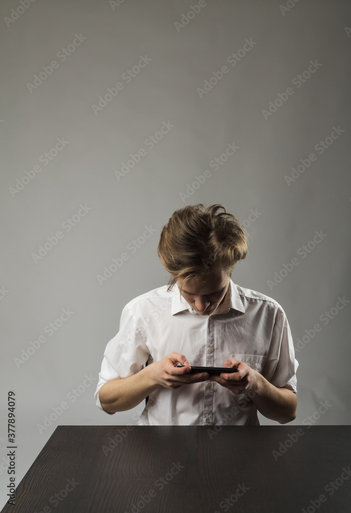 Fototapeta premium Young man in white using smartphone.