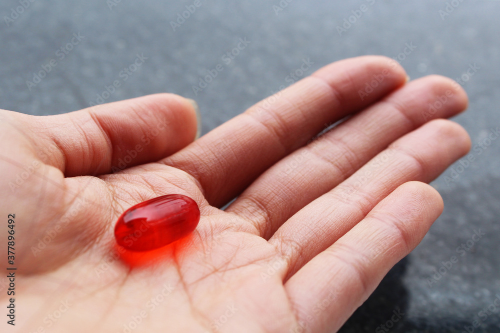 Hand holding a red pill Hand holding a red pill