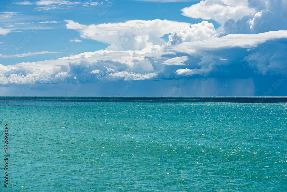 Cumulus Clouds (Cumulonimbus) with torrential rain on the horizon over the Mediterranean Sea. Gulf of La Spezia, Liguria, Italy, Europe