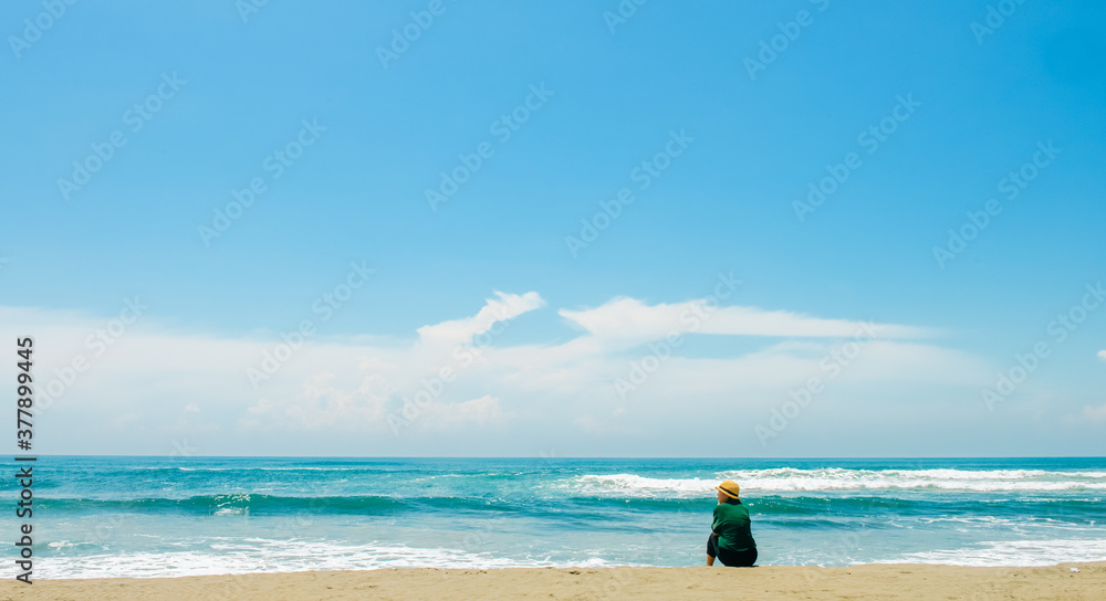 single girl enjoys herself standing on Parangtritis beach, Yogyakarta, Indonesia. single girl enjoys herself standing on Parangtritis beach, Yogyakarta, Indonesia.