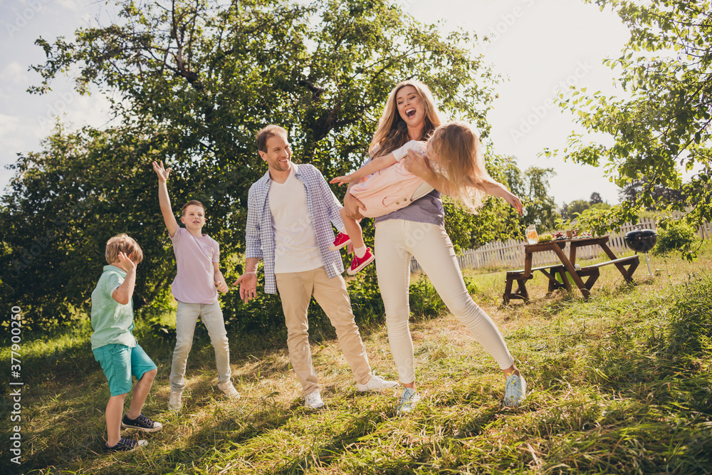Fototapeta premium Full body size photo of big full family five people three little kids gathering relax mom hold daughter funny game sons dance on sunny summer day comfort fenced home park backyard outside