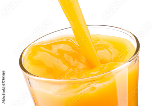 Foto Orange juice pouring into glass isolated on white background