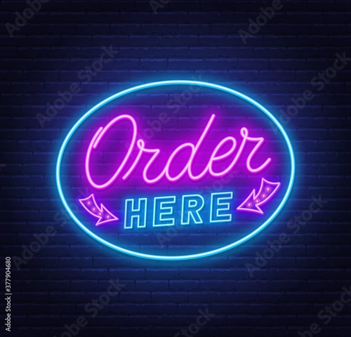 Order here neon sign on brick wall background .