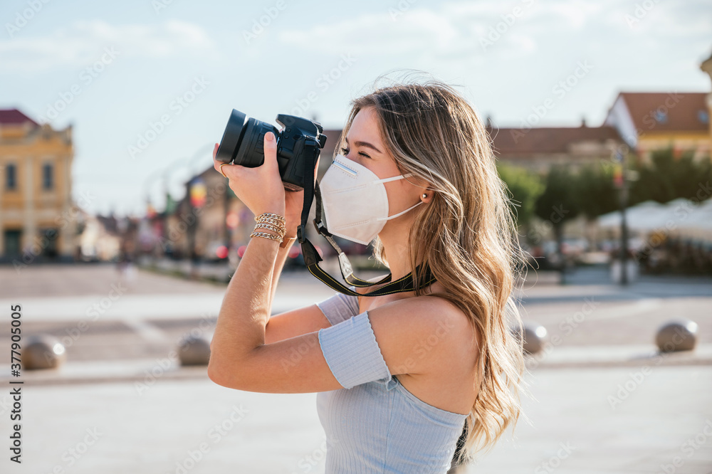 Tourist woman with mask taking photos in the city