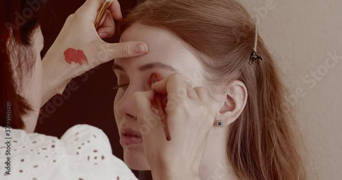 Makeup is applied to a beautiful young girl in the salon.