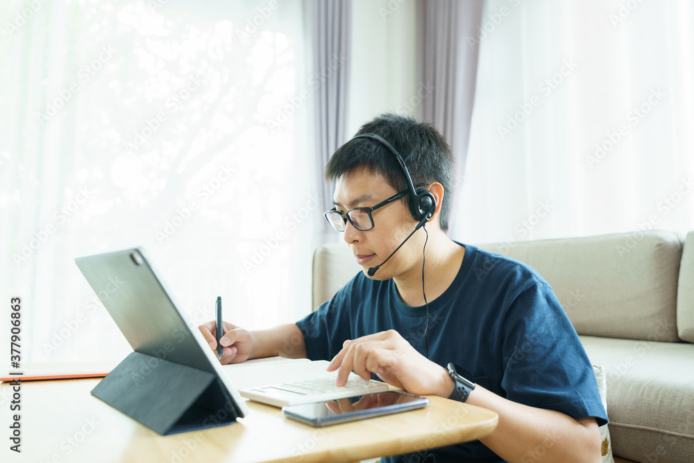 Asian man aged 30-40 years using tablet, watching lesson online course communicate by conference video call from home, e-learning education concept Asian man aged 30-40 years using tablet, watching lesson online course communicate by conference video call from home, e-learning education concept