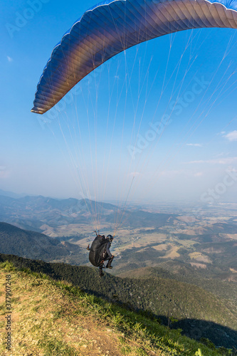 Saltando de parapente. Homem saltando de paraquedas no pico Agudo em Santo Antonio do Pinhal, São Paulo. Esporte radical.  photo