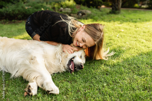 Valokuva Woman with dog Labrador having fun in green park