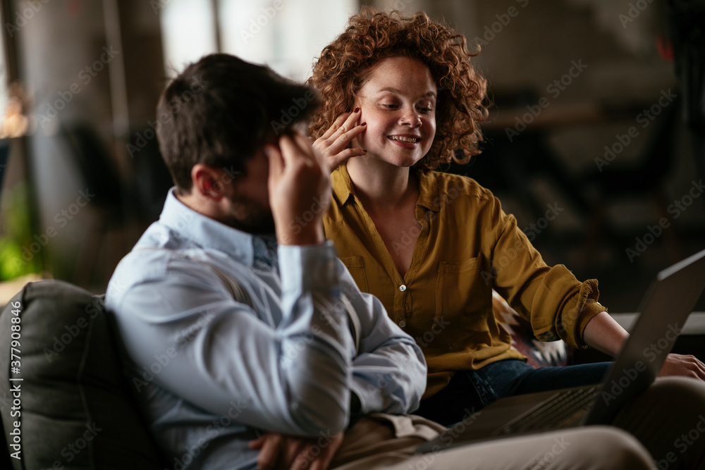Fototapeta premium Colleagues sitting and talkig in office. Businesswoman and businessman discussing work in office...