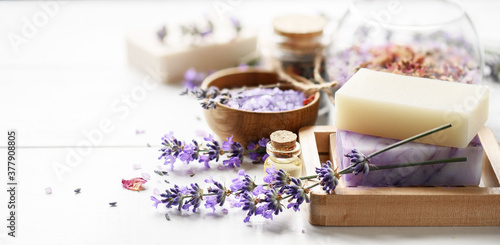 Lavender's soap and Spa products with lavender flowers on a white table.