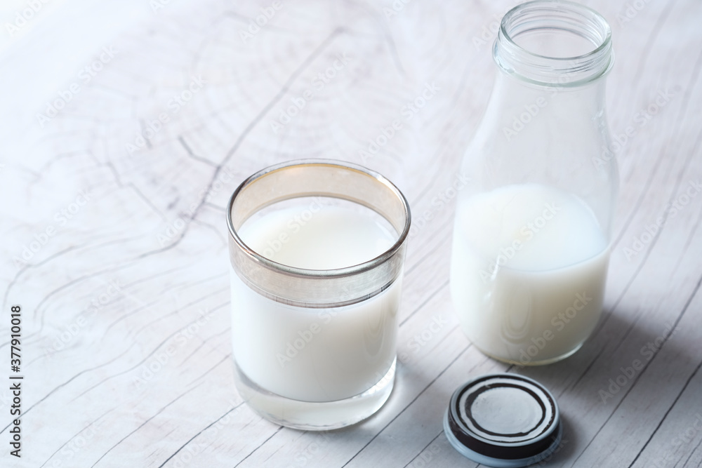 Close up of glass of milk and jar on table Close up of glass of milk and jar on table