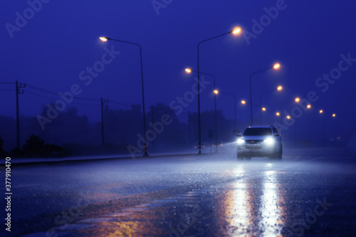 Wet road with light reflections,.twilight scene during hard rain fall.Selective focus with shallow depth of field.