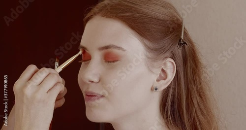 Makeup is applied to a beautiful young girl in the salon.