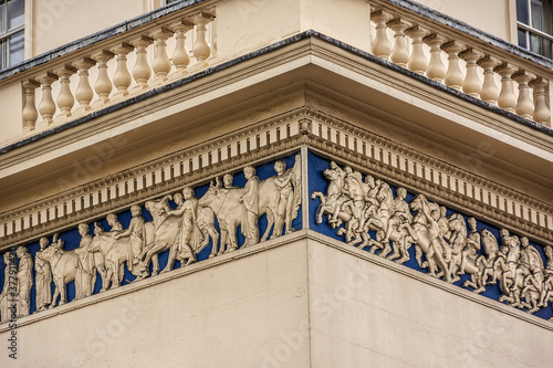 Street scene in the central London: Neoclassical style Athenaeum building (1824) at 107 Pall Mall at the corner of Waterloo Place. London, England, UK. photo