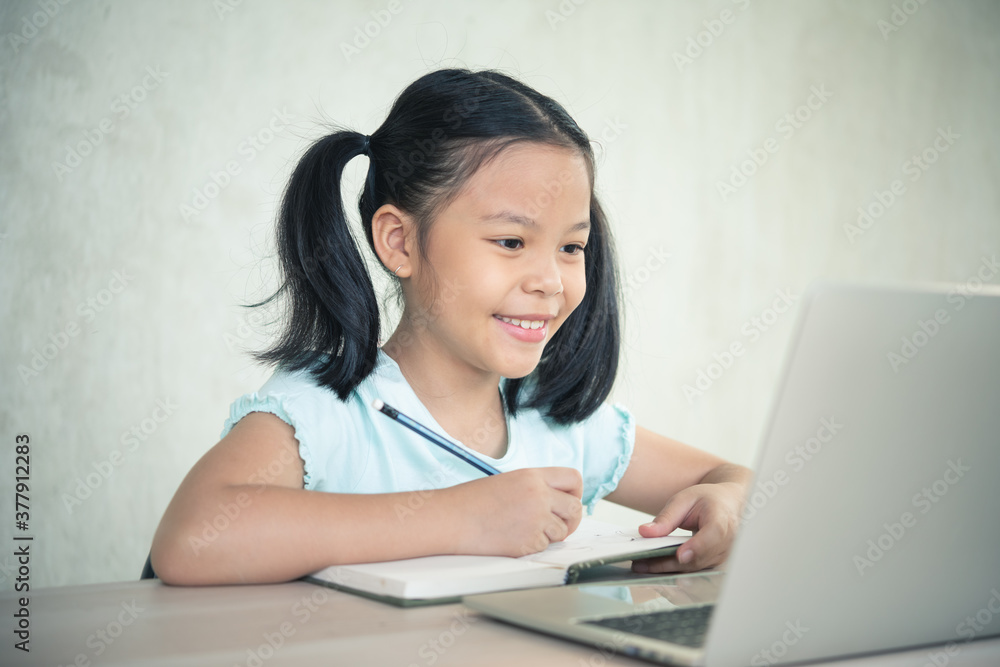 Asian girl student online learning class study online video call zoom teacher, Happy girl learn online with laptop at home.New normal. Covid-19 coronavirus, Social distancing, education anywhere. Asian girl student online learning class study online video call zoom teacher, Happy girl learn online with laptop at home.New normal. Covid-19 coronavirus, Social distancing, education anywhere.
