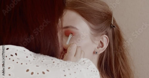 Makeup is applied to a beautiful young girl in the salon.