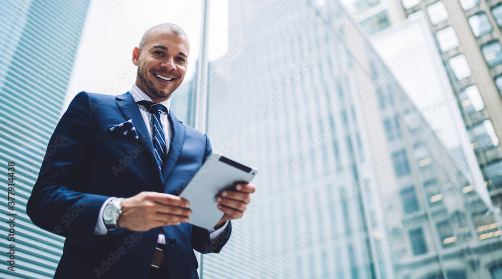 Fototapeta premium Excited businessman using tablet in downtown