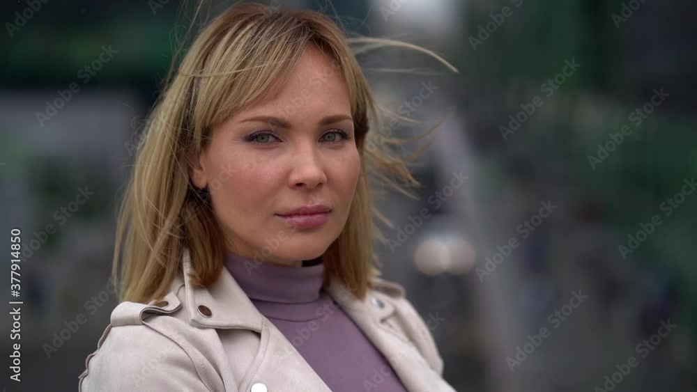 Portrait of a beautiful blonde leader standing on the street against the background of a business center Portrait of a beautiful blonde leader standing on the street against the background of a business center