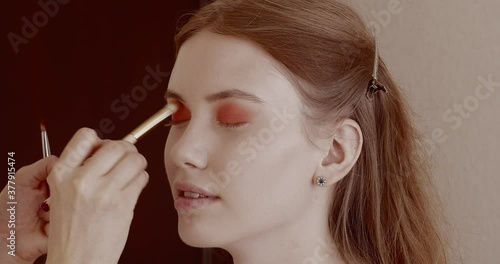 Makeup is applied to a beautiful young girl in the salon.
