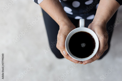 Coffee cup on the hand of elderly women