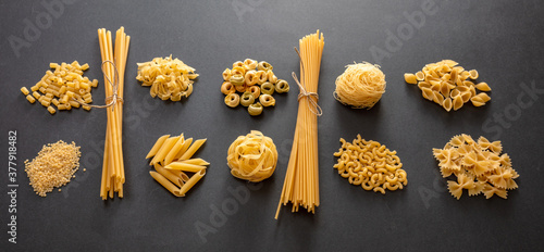 Pasta assortment on black background, top view. Cooking italian cuisine concept