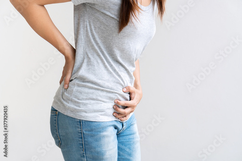 Young Asian woman suffering from menstrual cramps. Isolated on white background. Gynecology concept
