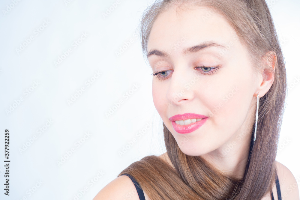 Portrait of a young girl with long smooth hair. Girl's face on a white background. A woman with downcast eyes. The face of a girl with long earrings. Portrait of a young girl with long smooth hair. Girl's face on a white background. A woman with downcast eyes. The face of a girl with long earrings.