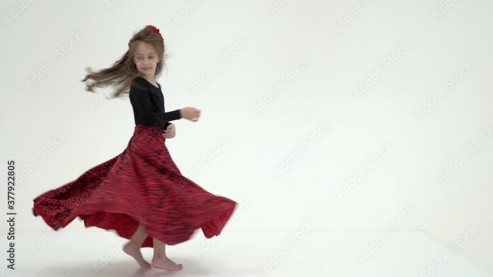 Beautiful little girl in a dress is spinning in dance. The concept of a happy childhood, dancing, holidays.On a white background.
