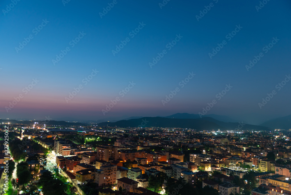 Panorama of the top view of the city in the evening just after sunset. Brescia seen from the castle at night timelapse.