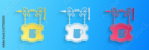 Paper cut Street signboard on forged brackets with wooden mug of beer icon isolated on blue background. Suitable for bar, tavern, cafe, pub, restaurant. Paper art style. Vector.