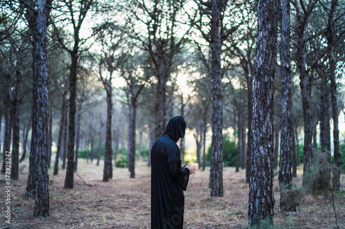 Chico disfrazado de monje oscuro en halloween en un bosque