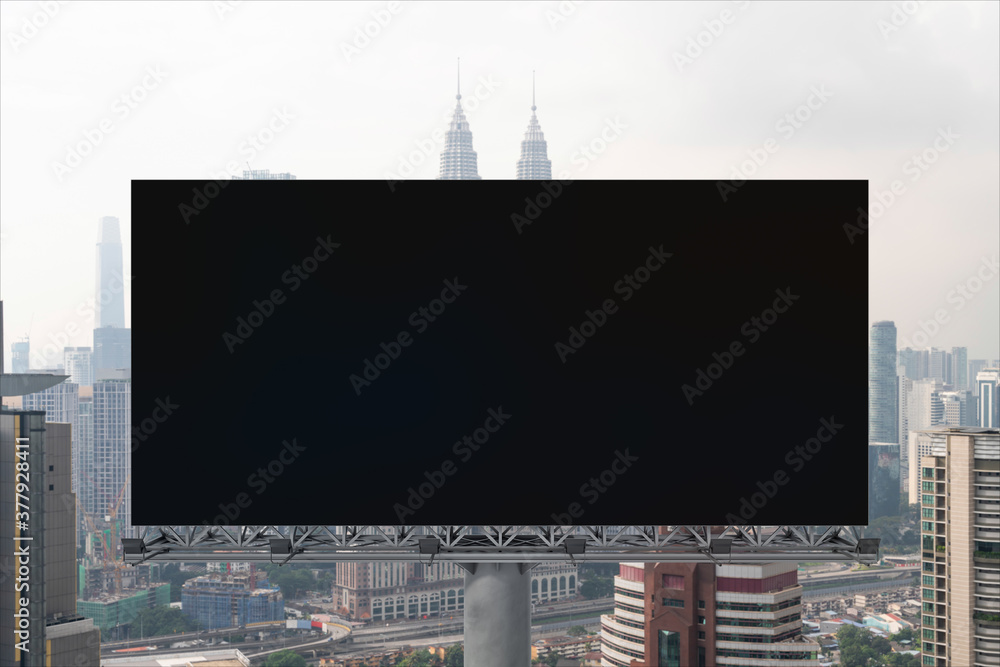 Fototapeta premium Blank black road billboard with Kuala Lumpur cityscape background at day time. Street advertising poster, mock up, 3D rendering. Front view. Concept of marketing to promote or sell services or ideas.