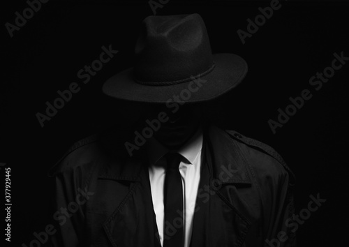 Old fashioned detective in hat on dark background photo