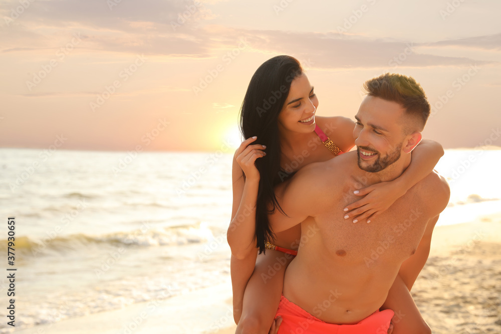 Happy young couple having fun on beach on sunny day Happy young couple having fun on beach on sunny day