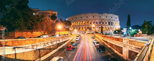 Rome, Italy. Colosseum Also Known As Flavian Amphitheatre. Traffic In Rome Near Famous World Landmark In Evening Time.