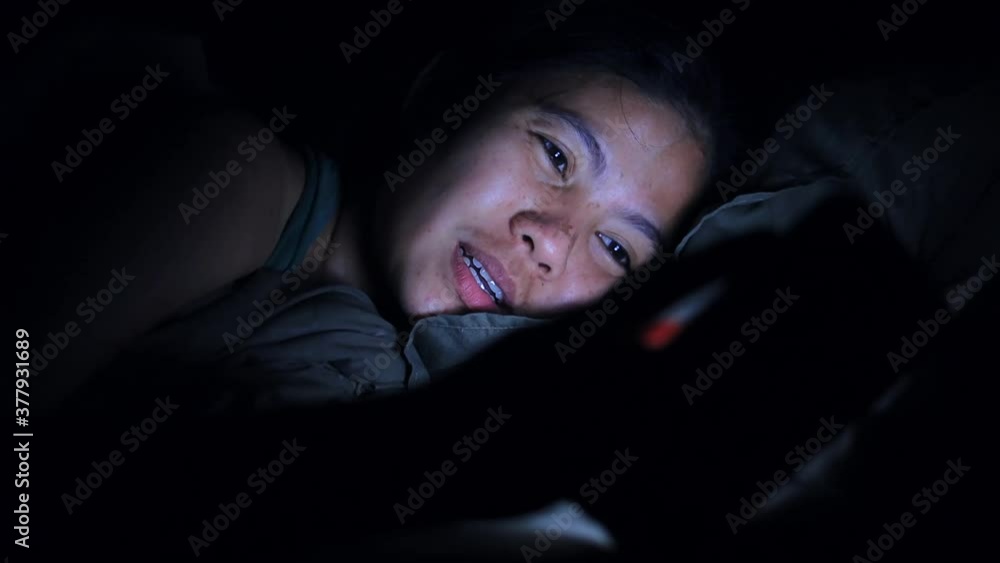 Asian woman using smartphone in the bed at night Asian woman using smartphone in the bed at night