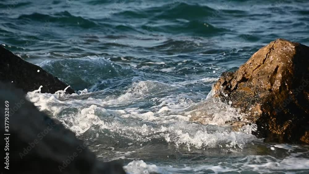The waves hit the rocky shore. Stormy sea after a strong wind. Long angle lens, close up, slow motion, static The waves hit the rocky shore. Stormy sea after a strong wind. Long angle lens, close up, slow motion, static