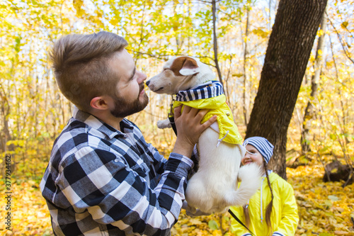 Man with his dog at autumn park. Guy playing with jack russell terrier outdoors. Pet and people concept.