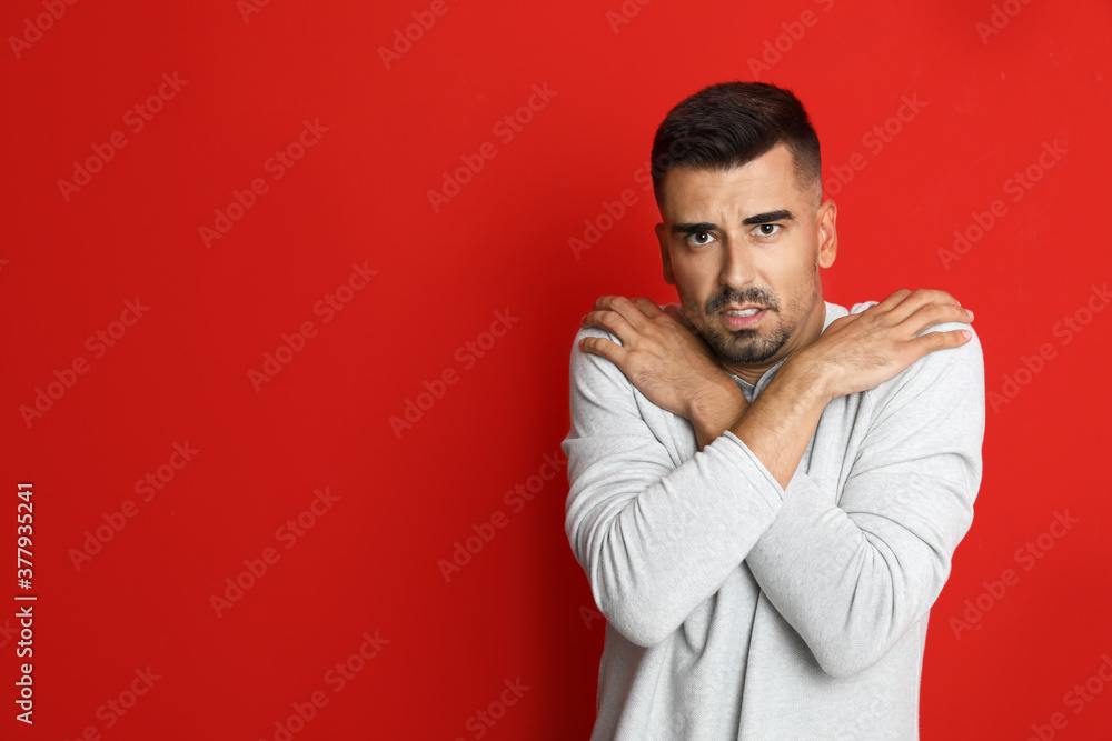 Man suffering from fever on red background, space for text. Cold symptoms Man suffering from fever on red background, space for text. Cold symptoms