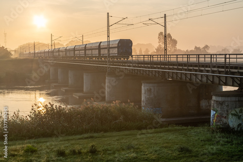 pociąg towarowy na moście w porannej mgle