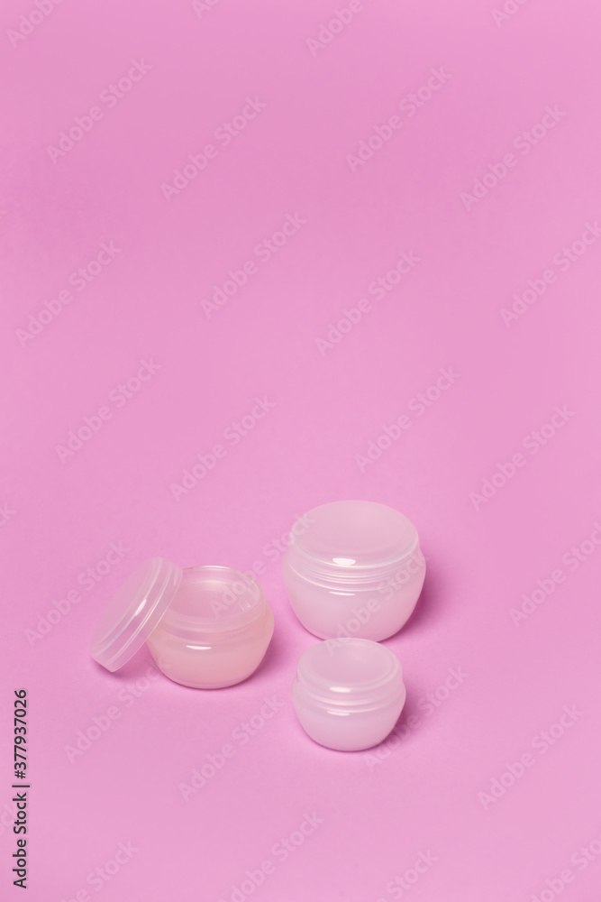 Cosmetic jars on a pink background Cosmetic jars on a pink background