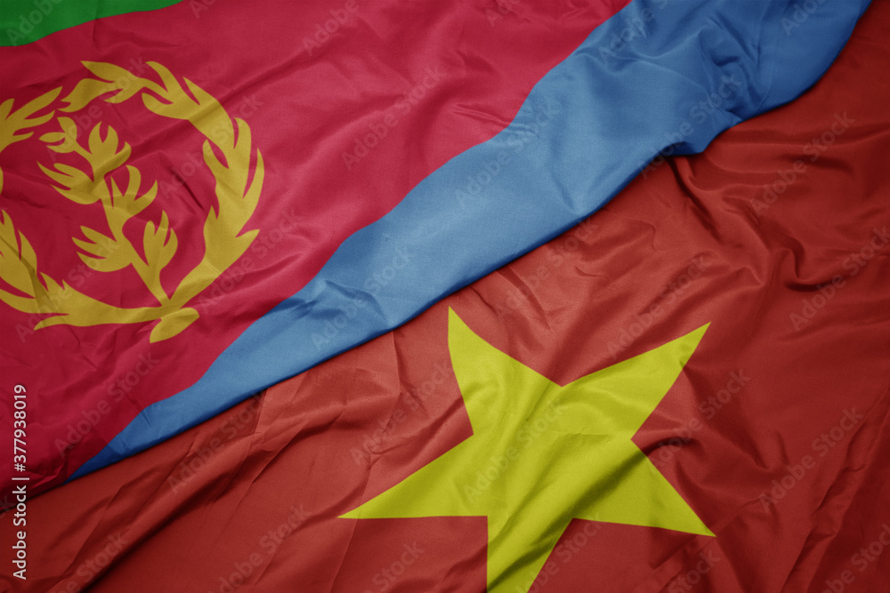 waving colorful flag of vietnam and national flag of eritrea.