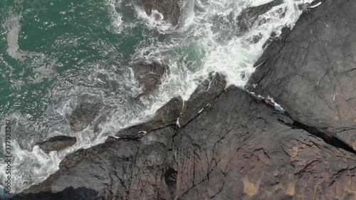 This is a aerial drone shot of Om Beach in Gokarna, India. This is a bird's eye view of waves crashing into rocks. photo